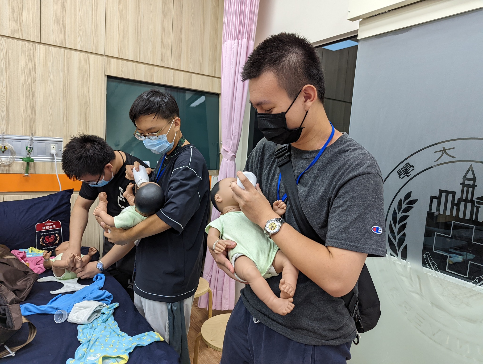 圖為參與AI醫療專題實作營同學,在亞大「醫療照護元宇宙教學基地」,使用護理系客製化VR元宇宙教材,體驗為小嬰兒拍痰,由醫護人員遠距了解動作是否正確