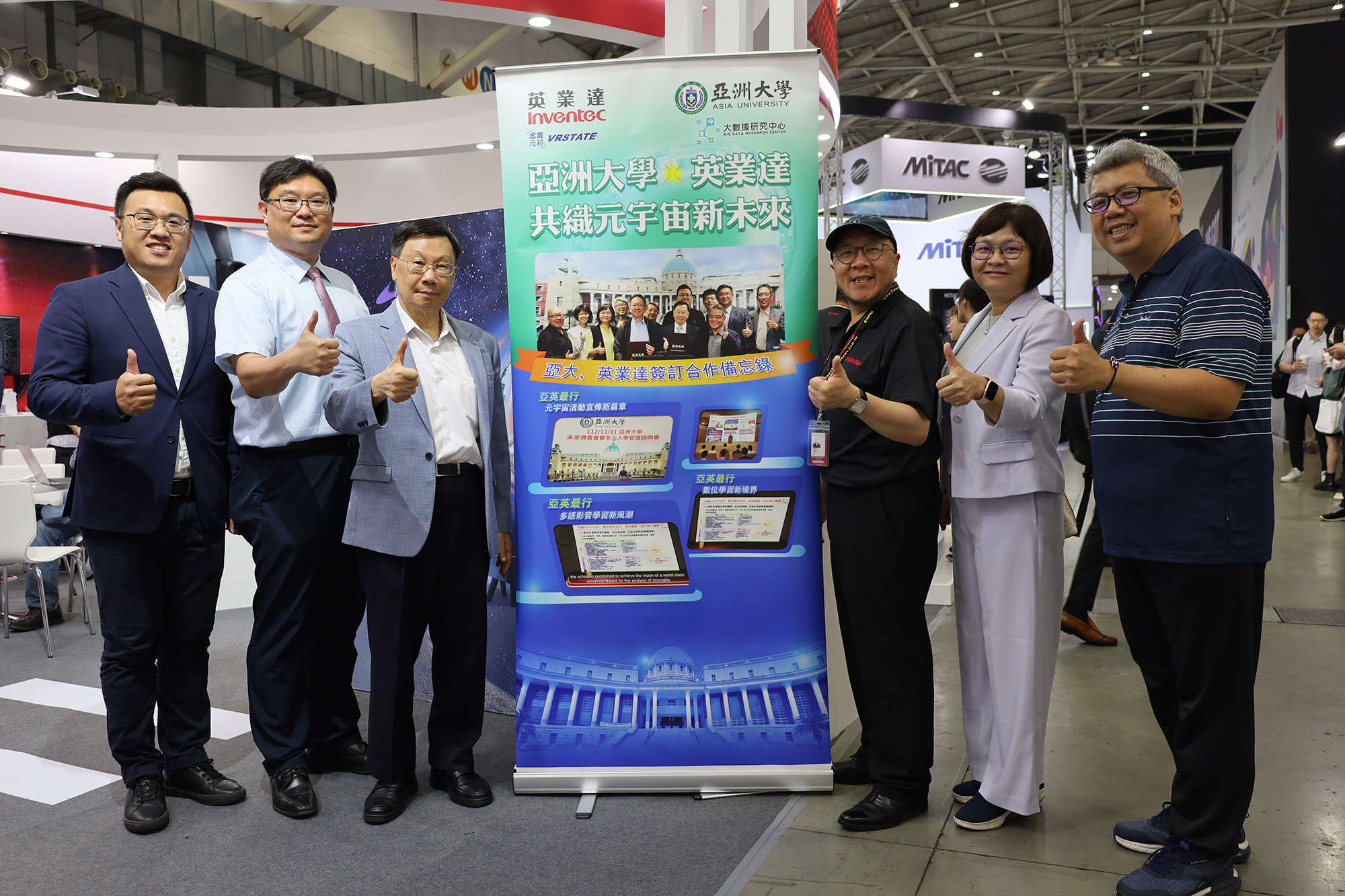 Inventec 's display at the Computex booth, showcasing their collaboration with Asia University on the "Metaverse Campus." Asia University President Jeffrey J.P. Tsai (left 3) is pictured with university officials and Inventec 's Senior Manager of Metaverse Technology Division, Lin Chao-Liang (right 3).