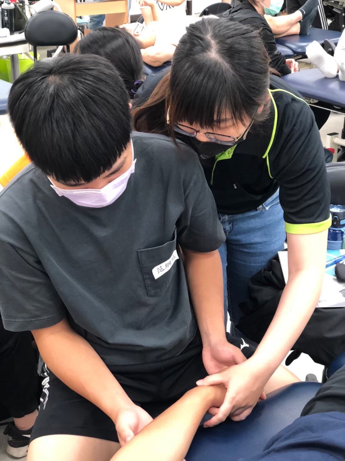 The first graduates from the Department of Physical Therapy of Asia University achieved a high pass rate in the physical therapist licensing examination. The image shows mentors guiding students through the process of physical therapy procedures