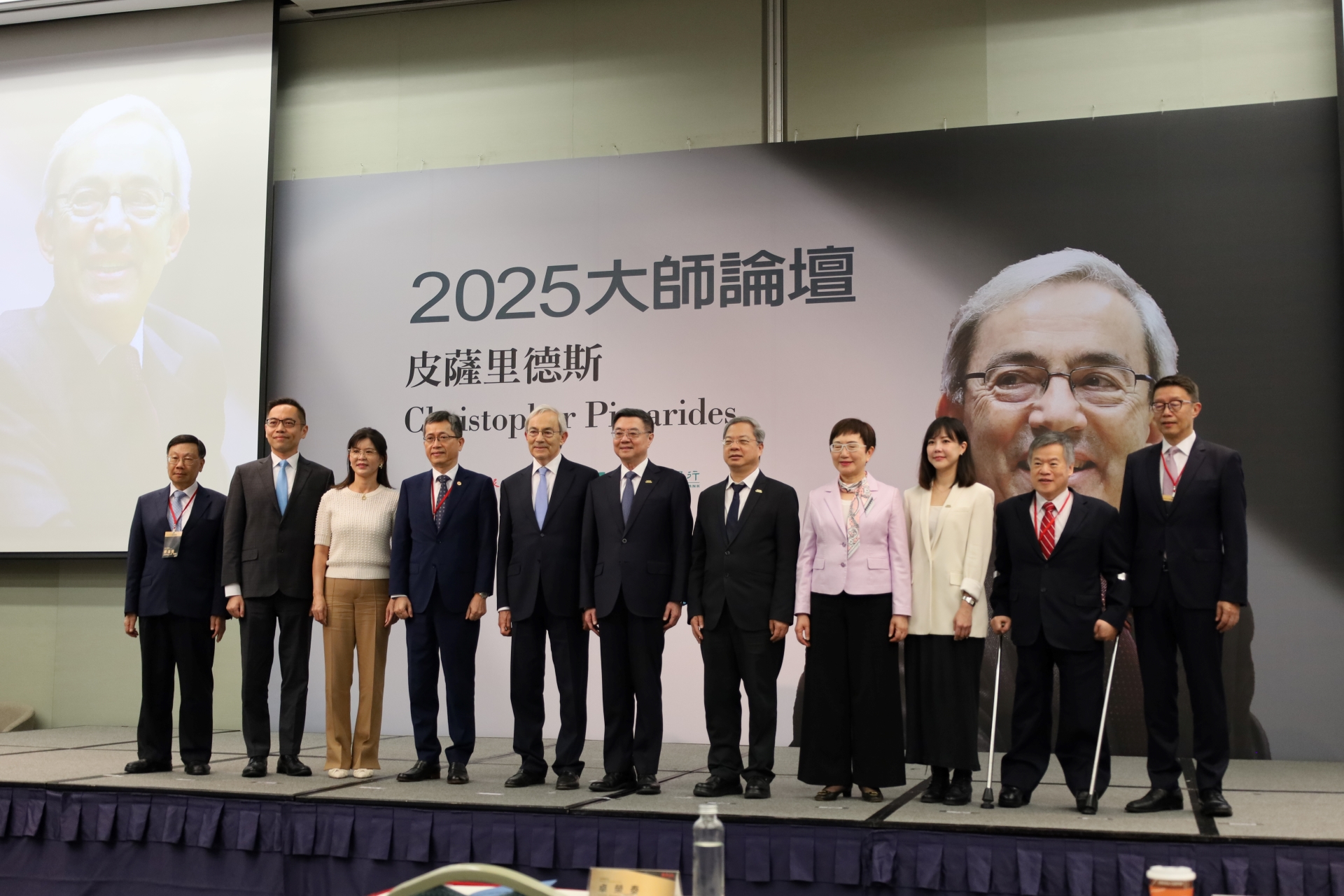 At the 2025 Nobel Laureate Forum, AU President Tsai (far left), Prof. Pissarides (fifth from left), Premier Cho Jung-tai, and other guests gather for a group photo